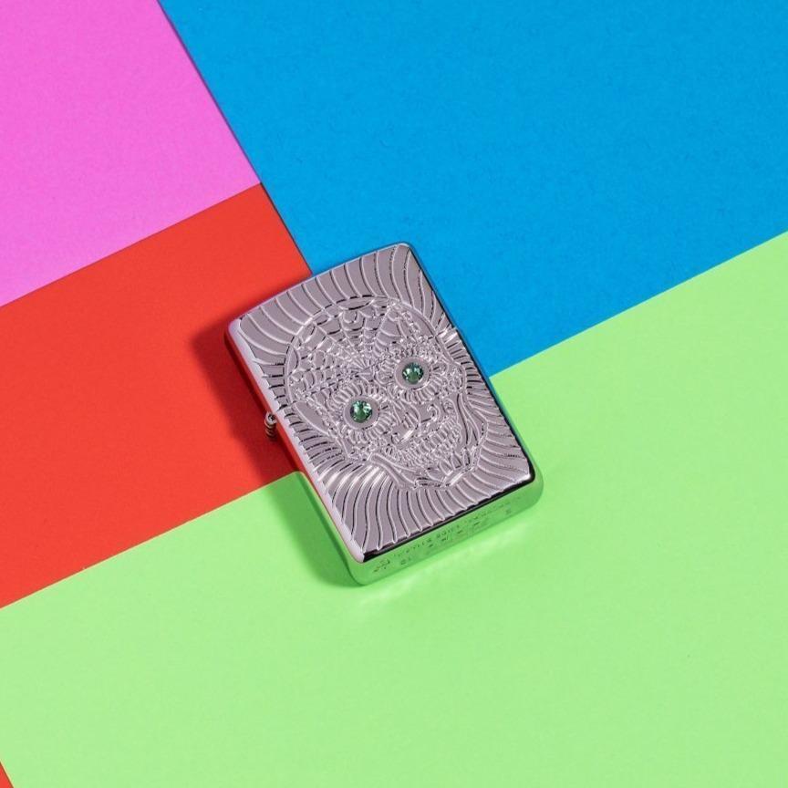 Lifestyle image of Armor Sugar Skull Design High Polish Chrome Windproof Lighter on a multicolored neon background
