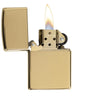 Classic High Polish Brass Windproof Lighter with its lid open and lit