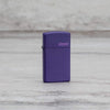 Lifestyle image of Slim® Purple Matte Zippo Logo Windproof Lighter standing on a marble surface