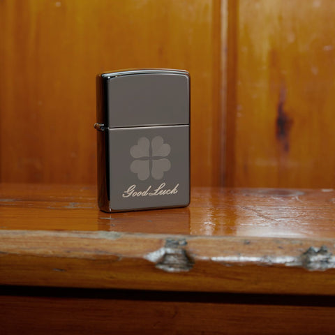 Lifestyle image of Good Luck Design Black Ice Windproof Lighter standing on a wooden banister 