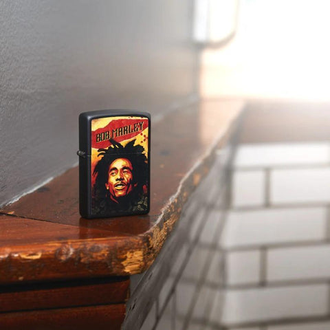 Lifestyle image of Bob Marley Illustrated Black Matte Lighter standing on wooden banister 
