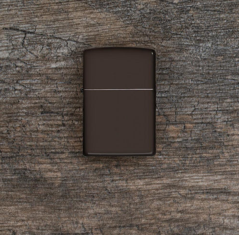 Lifestyle image of Brown Windproof Lighter laying flat on a wooden surface